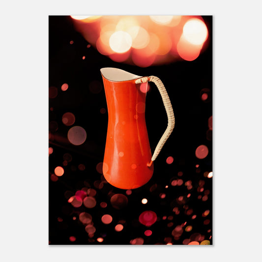 Retro poster med en orange kaffekanna designad av Jens H. Quistgaard för Kobenstyle, fotograferad i varmt vintage-ljus med bokeh-bakgrund