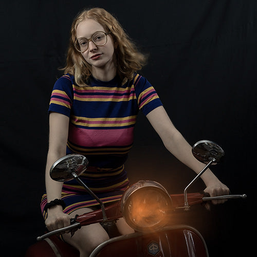 Ung dam i 70-talsstil sitter på en Piaggio från -72