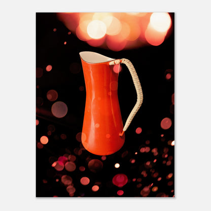 Retro poster med en orange kaffekanna designad av Jens H. Quistgaard för Kobenstyle, fotograferad i varmt vintage-ljus med bokeh-bakgrund