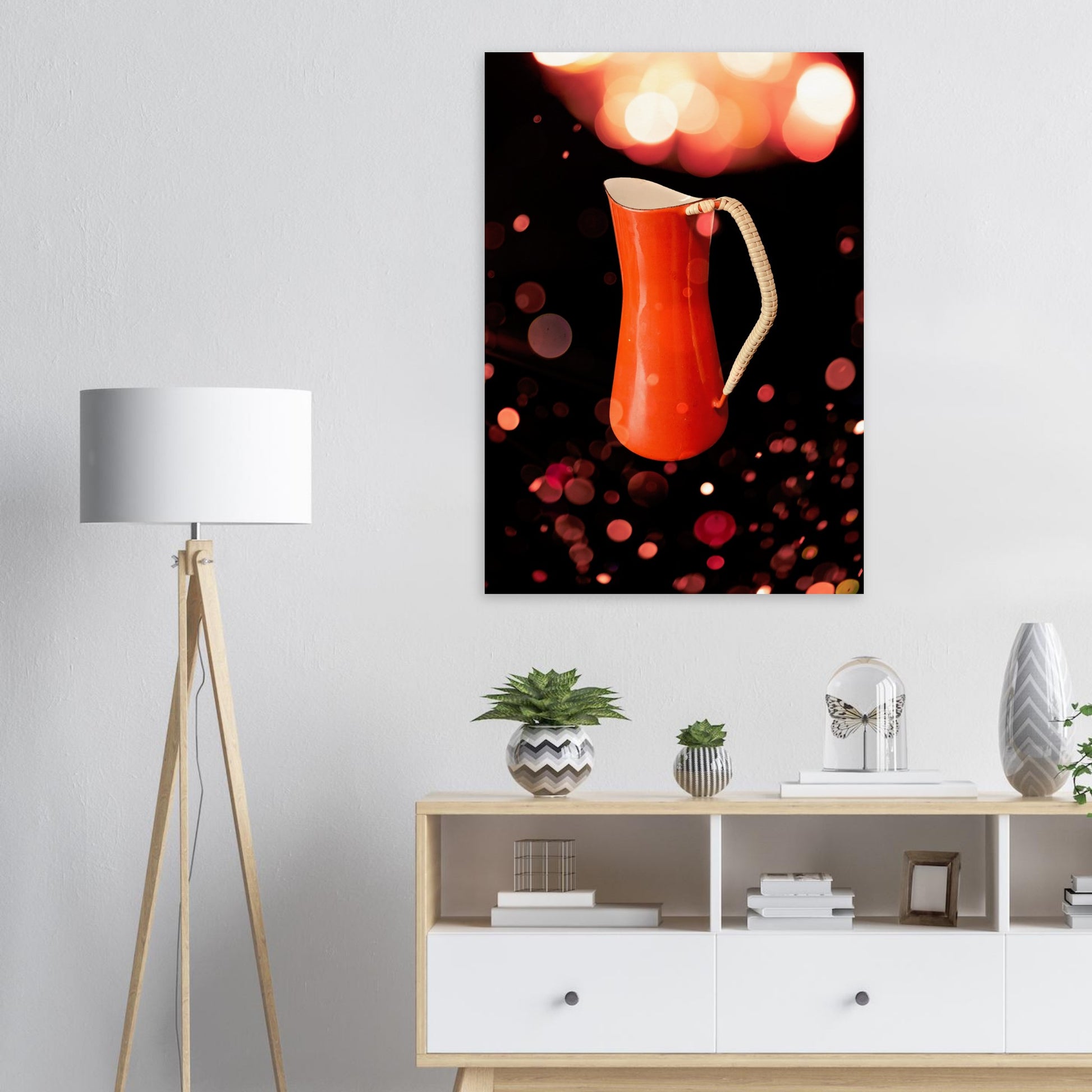 Retro poster med en orange kaffekanna designad av Jens H. Quistgaard för Kobenstyle, fotograferad i varmt vintage-ljus med bokeh-bakgrund hängandes på en vit vägg.